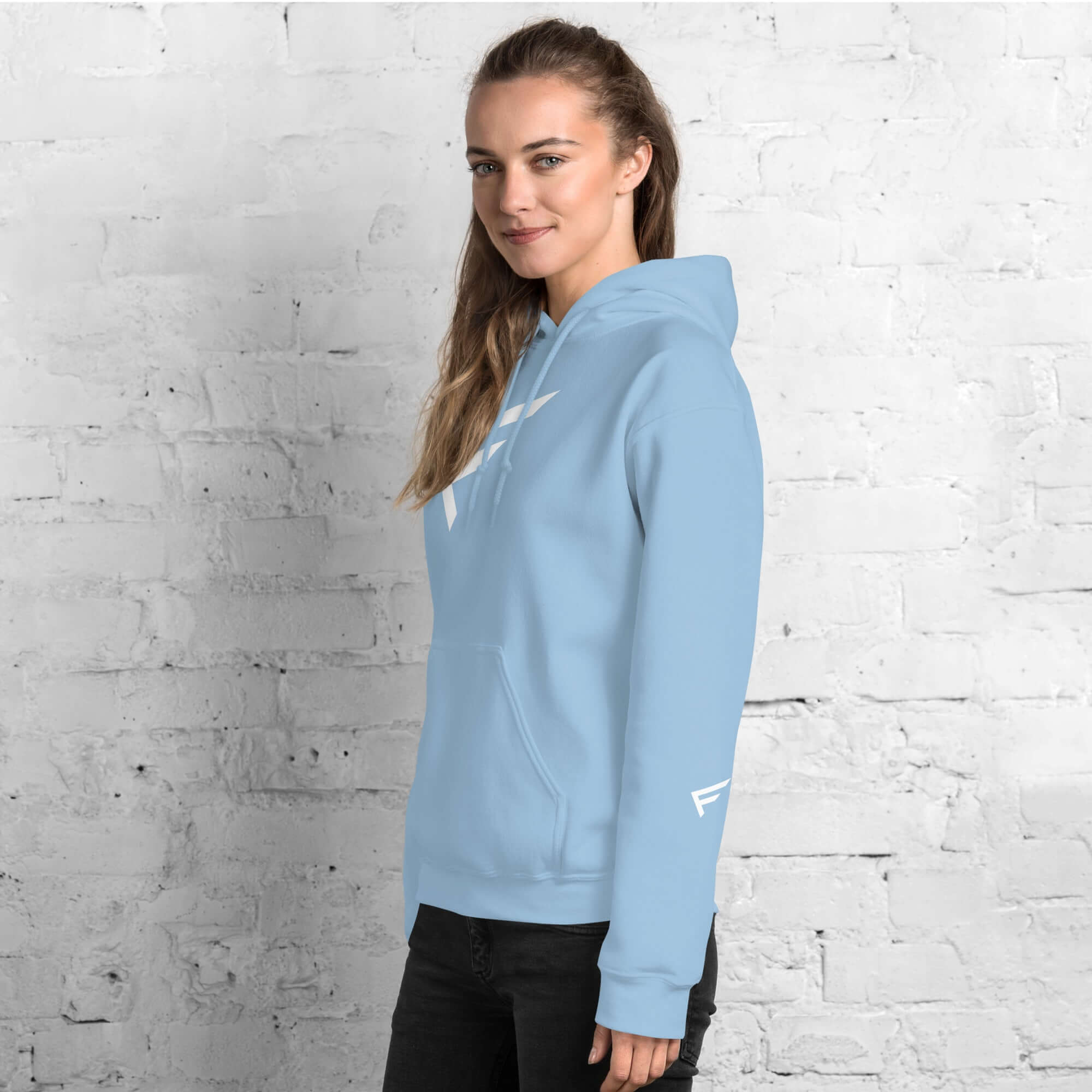 Woman wearing a light blue hoodie with signature 'F' emblem, designed for comfort and bold movement.