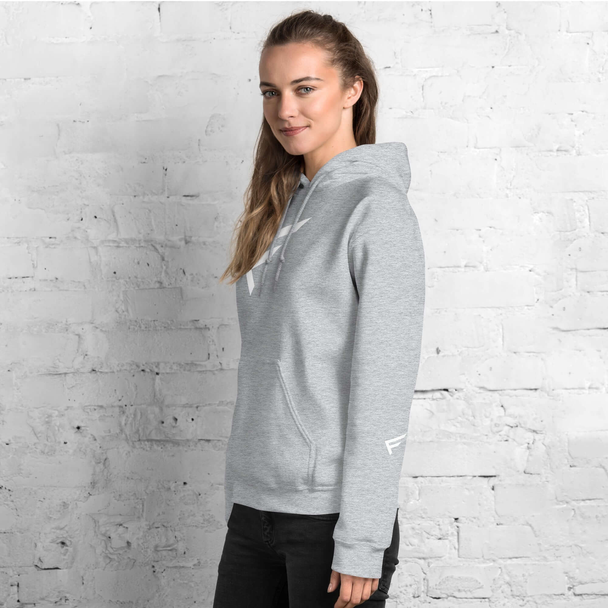 Stylish woman in limited-edition grey hoodie with 'F' emblem, perfect for comfort and bold movement.